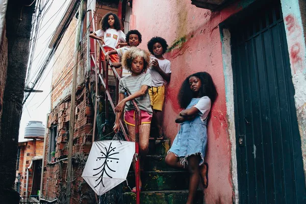 Crianças negras seguram pipa em escada - Metrópoles