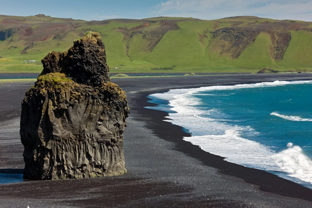 Praia de areia preta de Reynisfjara, localizada na costa sul da Islândia, perto da vila de Vík í Mýrdal Praia de areia preta de Reynisfjara, localizada na costa sul da Islândia, perto da vila de Vík í Mýrdal