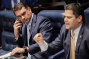 O presidente do Senado, Davi Alcolumbre, com Flávio Bolsonaro ao lado