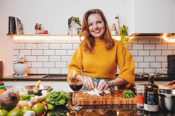 mulher posa sorrindo enquanto cozinha - metrópoles