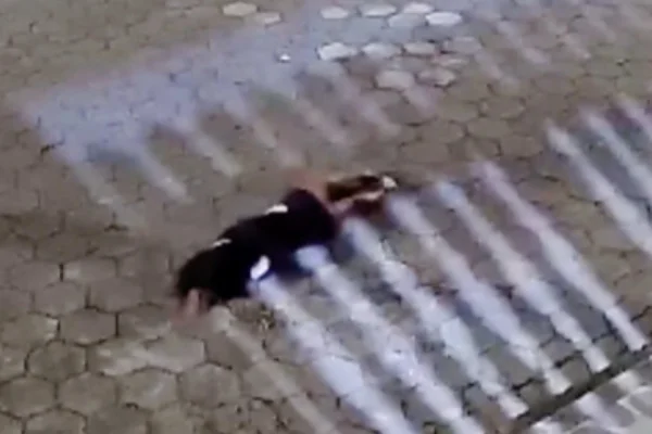 Imagem colorida de mulher desmaiada no chão após ser agredida. Metrópoles