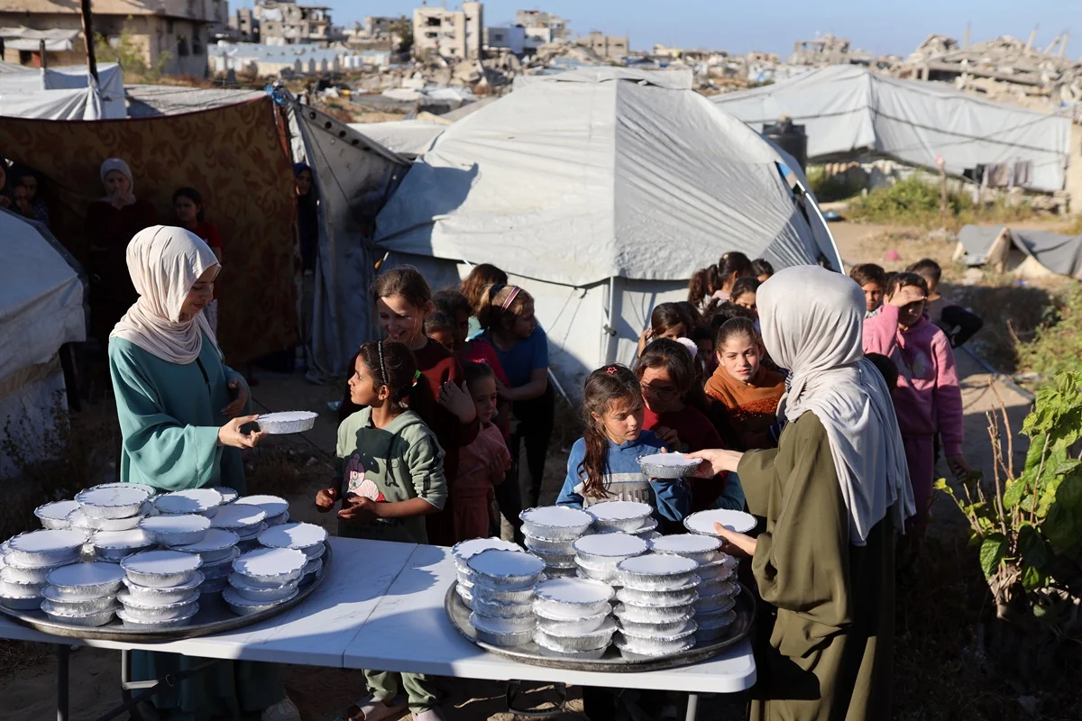 As irmãs palestinas Lina Zeid (à esquerda) e Aya Zeid distribuem pacotes de alimentos para crianças deslocadas em Gaza As irmãs palestinas Lina Zeid (à esquerda) e Aya Zeid distribuem pacotes de alimentos para crianças deslocadas em Gaza