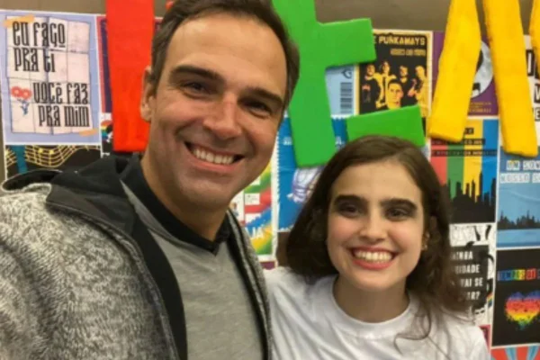 Tadeu Schmidt com a filha, Valentina, que é queer, em um cenário colorido - Metrópoles
