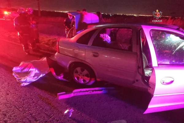 carro destruído ao lado de corpo de homem no chão
