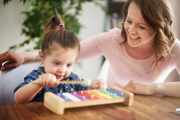 Mãe e filha brincando juntas. Musicoterapia para crianças autistas. Metrópoles