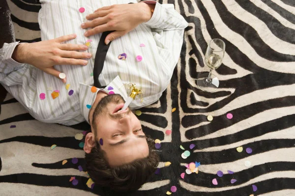 Imagem colorida de homem caído no chão após festejos
