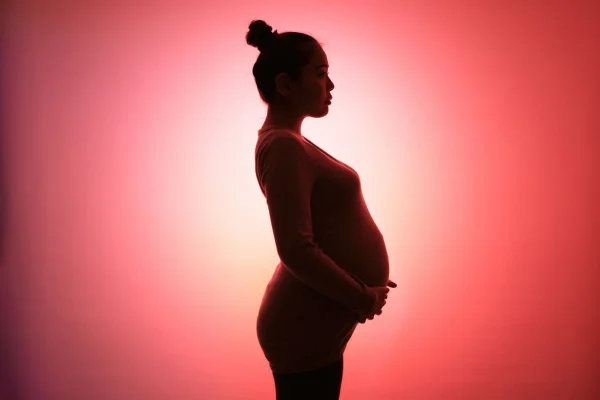 imagem de uma mulher grávida em um fundo vermelho