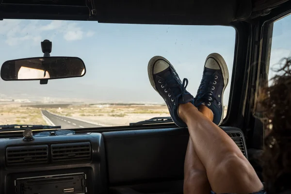 Mulher com pernas para o alto em carro