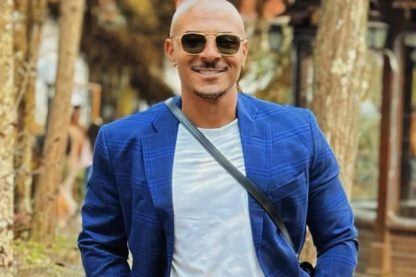 Lucas Ferraz posa de terno azul e óculos escuros - Metrópoles