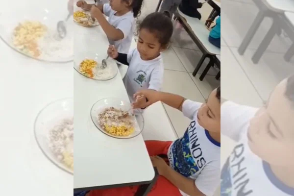 Foto colorida de duas crianças comendo - Metrópoles