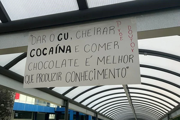 Cartaz colado em muro de universidade