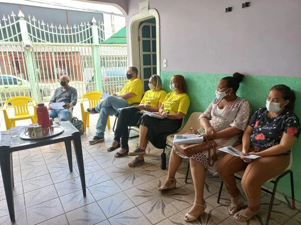 Grupo de pessoas reunido sentado em cadeiras
