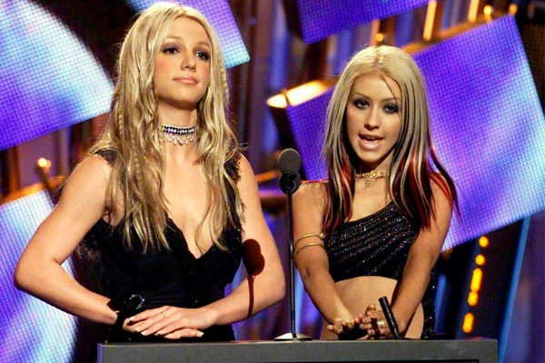 Britney Spears e Christina Aguilera foram amigas de infância quando apresentavam o programa “Mickey Mouse Club” no Disney Channel. Depois que se tornaram divas do pop, elas acumularam fãs, hits nas paradas de sucesso e brigas ocasionais. A relação inconstante se limita a elogios e farpas. Mesmo que atualmente tudo aparente estar tudo bem. A maior briga aconteceu em 2003, quando cantaram ao lado de Madonna numa edição especial do Video Music Awards. Christina disse à revista Blender que nos ensaios Britney estava “distante” e parecia alguém “perdido que precisa de orientação”. Britney rebateu os comentários e declarou que não via Aguilera há dois anos. "Ela veio até mim em uma festa e tentou enfiar a língua na minha garganta!" Spears afirmou. "Eu disse: 'É bom ver você', e ela respondeu: 'Você não está sendo real comigo'. E eu falei, 'Christina, qual a sua definição de real? Beijar uma garota que você não vê há dois anos?'" Britney Spears e Christina Aguilera foram amigas de infância quando apresentavam o programa “Mickey Mouse Club” no Disney Channel. Depois que se tornaram divas do pop, elas acumularam fãs, hits nas paradas de sucesso e brigas ocasionais. A relação inconstante se limita a elogios e farpas. Mesmo que atualmente tudo aparente estar tudo bem. A maior briga aconteceu em 2003, quando cantaram ao lado de Madonna numa edição especial do Video Music Awards. Christina disse à revista Blender que nos ensaios Britney estava “distante” e parecia alguém “perdido que precisa de orientação”. Britney rebateu os comentários e declarou que não via Aguilera há dois anos. "Ela veio até mim em uma festa e tentou enfiar a língua na minha garganta!" Spears afirmou. "Eu disse: 'É bom ver você', e ela respondeu: 'Você não está sendo real comigo'. E eu falei, 'Christina, qual a sua definição de real? Beijar uma garota que você não vê há dois anos?'"