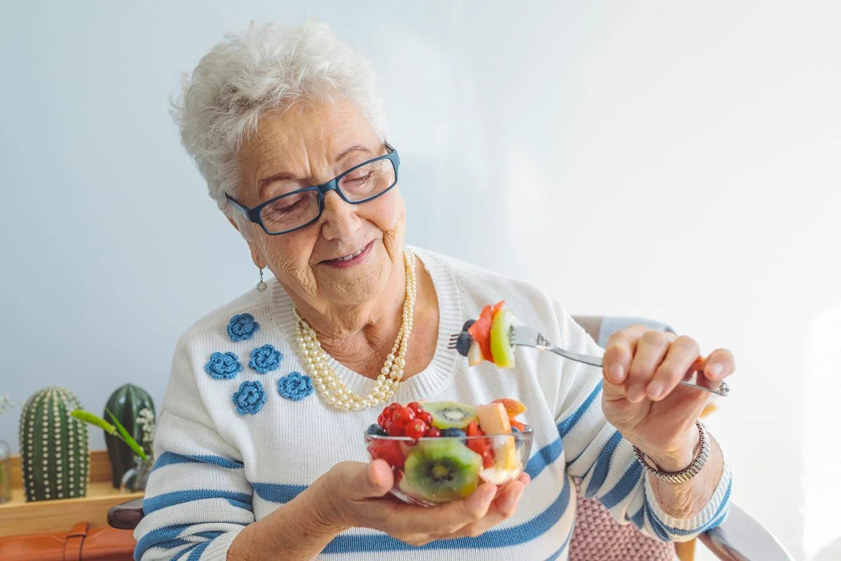 Foto colorida de mulher segurando tigela com frutas cortadas - Metrópoles
