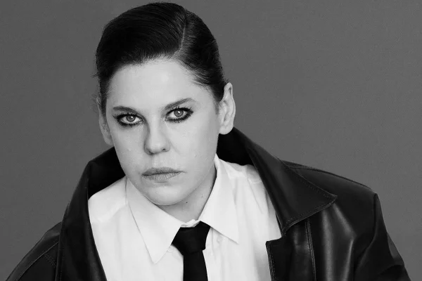 Barbara Paz com expressão séria em foto preto e branco. Ela usa camisa, gravata e jaqueta de couro - Metrópoles