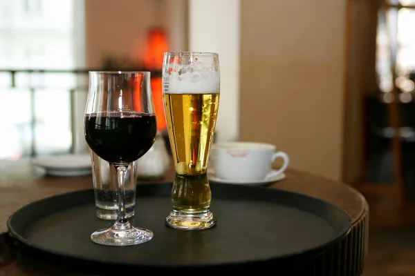 Taça de vinho e cerveja em cima de uma mesa. Metrópoles