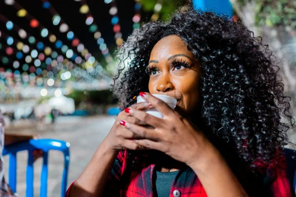 foto mulher negra tomando quentao em festa junina