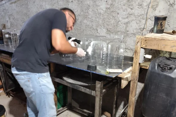 Foto colorida de policial analisando equipamentos de laboratório do PCC, no Guarujá, litoral sul de São Paulo.