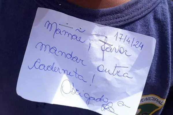 Foto colorida de menino com bilhete grampeado na blusa no Rio de Janeiro - Metrópoles