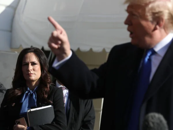 Foto colorida da ex-secretária de imprensa da Casa Branca, Stephanie Grisham, ouvindo o presidente dos EUA, Donald Trump, falar com os repórteres, em 2019 - Metrópoles