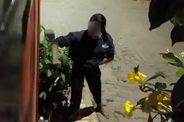 garota com braço estendido e punho fechado em portão