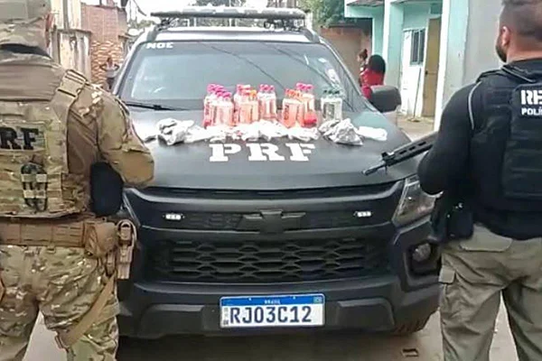 na foto vemos um camburão da PRF e dois policiais, um de cada lado