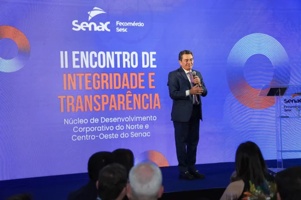 Fotografia colorida mostrando homem de terno em palco-Metrópoles