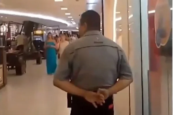 Imagem colorida mostra segurança intimidado por mulher que entrou descalça em shopping - Metrópoles