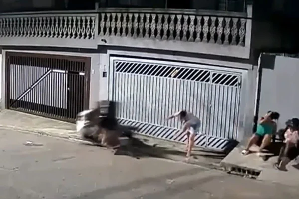 Imagem colorida mostra motociclista atropelando bombeiro que conversava com amigos na frente de casa na zona leste de São Paulo - Metrópoles