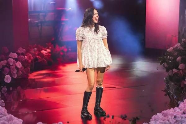 foto com cor. cantora olivia rodrigo vestindo babydoll rosa de flores em show - metrópoles