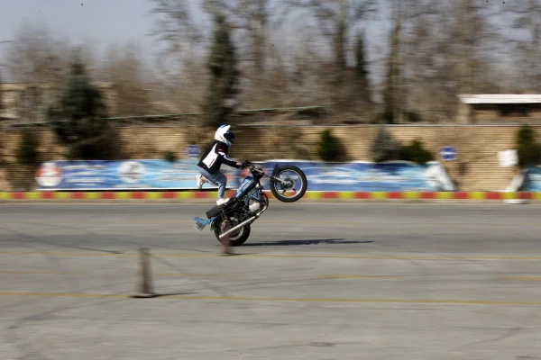 Foto colorida de mulher iraniana durante aulas de direção de motocicleta no Irã - Metrópoles