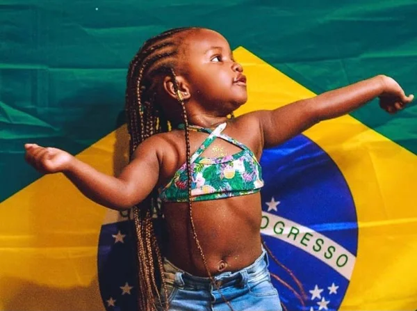 criança com bandeira do Brasil ao fundo