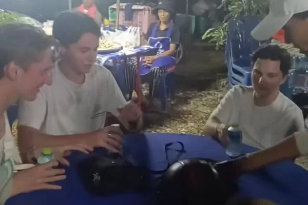 turistas sentados em mesa de funeral na Tailândia