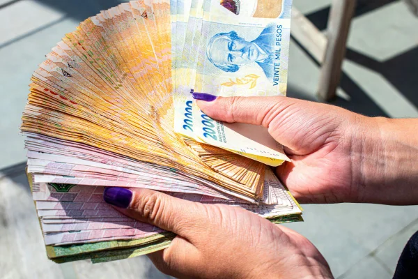 foto de pesos argentinos na mão de uma mulher