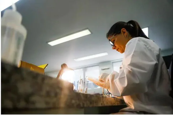 Foto colorida de uma cientistas analisando amostras em um laboratório de Florianópolis - Metrópoles