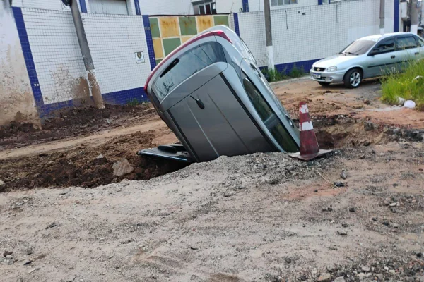 Motorista bêbado imbica carro em cratera de obra e foge.