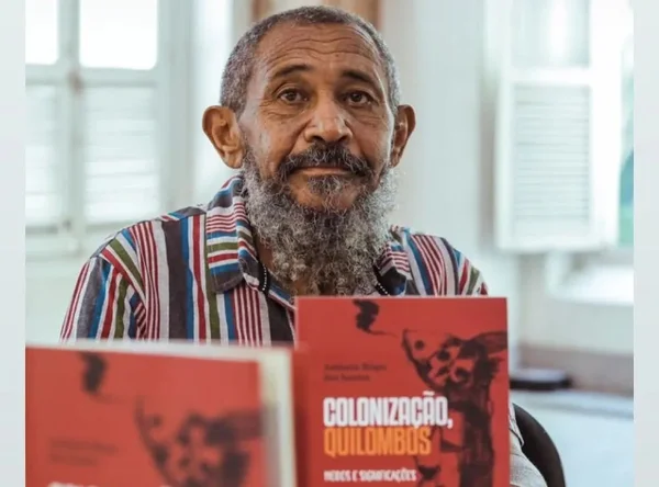 Imagem colorida de Nêgo Bispo segurando livro - Metrópoles