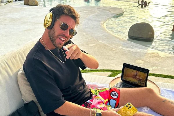 imagem colorida de Diego Aguiar sentado, com fone e óculos escuros - Metrópoles