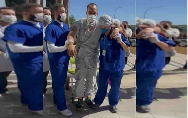 Péricles de roupão do hospital e tênis segurando pelos enfermeiro enquanto levanta da cadeira de rodas
