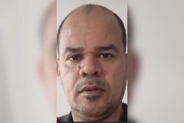 Foto colorida de homem preso por abusar sexualmente de passageira durante corrida por aplicativo.