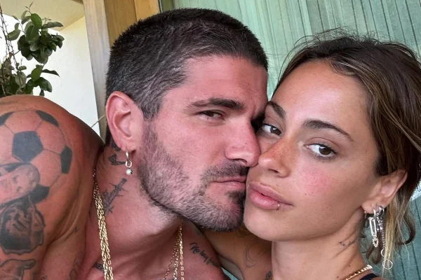 Foto colorida de homem beijando mulher no rosto - Metrópoles