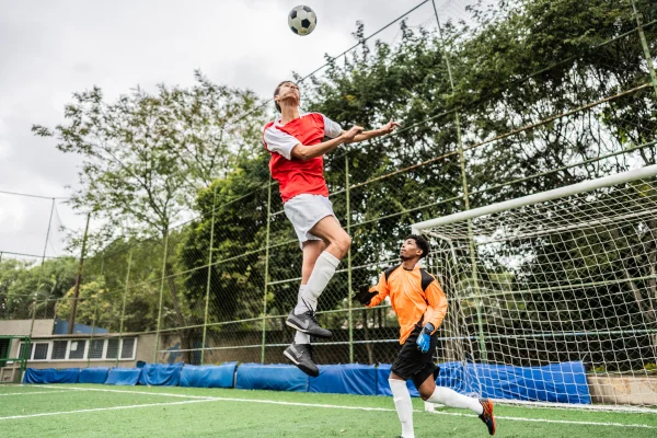 Foto de Jogador de futebol cabeceando a bola no campo de futebol. Metrópoles