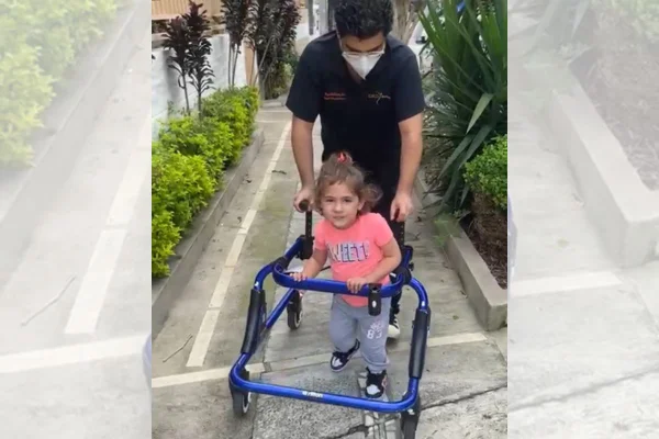 Imagem colorida: menina caminha com andador - Metrópoles