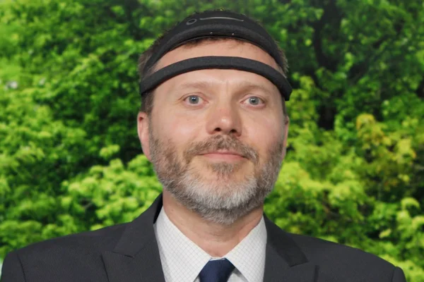 Foto de homem de terno e gravata com bandana tecnológica - Metrópoles