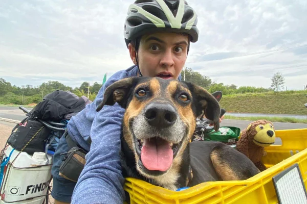 Foto colorida de uma mulher e seu cachorro - Metrópoles