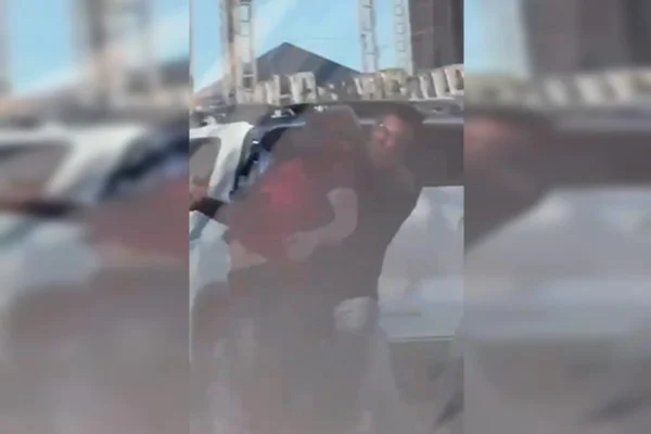 Foto colorida de homem aplicando mata-leão em jornalista