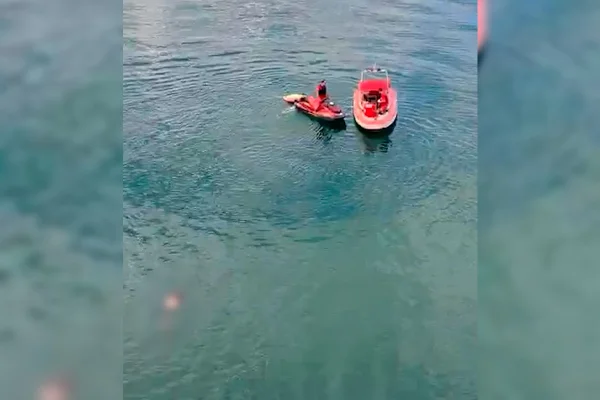 um jet ski e um barco do bombeiro e um corpo boiando no lago