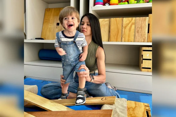 Foto de Joaquim, bebê com síndrome Charge , com a terapeuta Ana Carolina Martinez durante sessão. Metrópoles