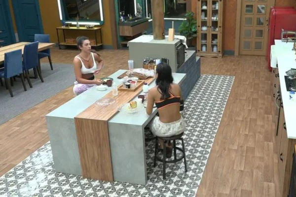 Pétala Barreiros e Bia Miranda sentadas em lados opostos de uma ilha de cozinha - metrópoles