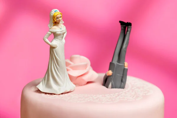 Foto colorida de um bolo de casamento com dois boneco em cima - Metrópoles